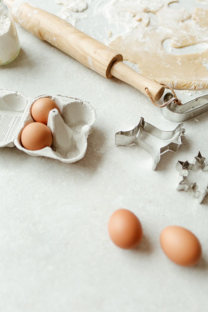 A collection of baking tools, ingredients, and cookie cutters on a kitchen counter.